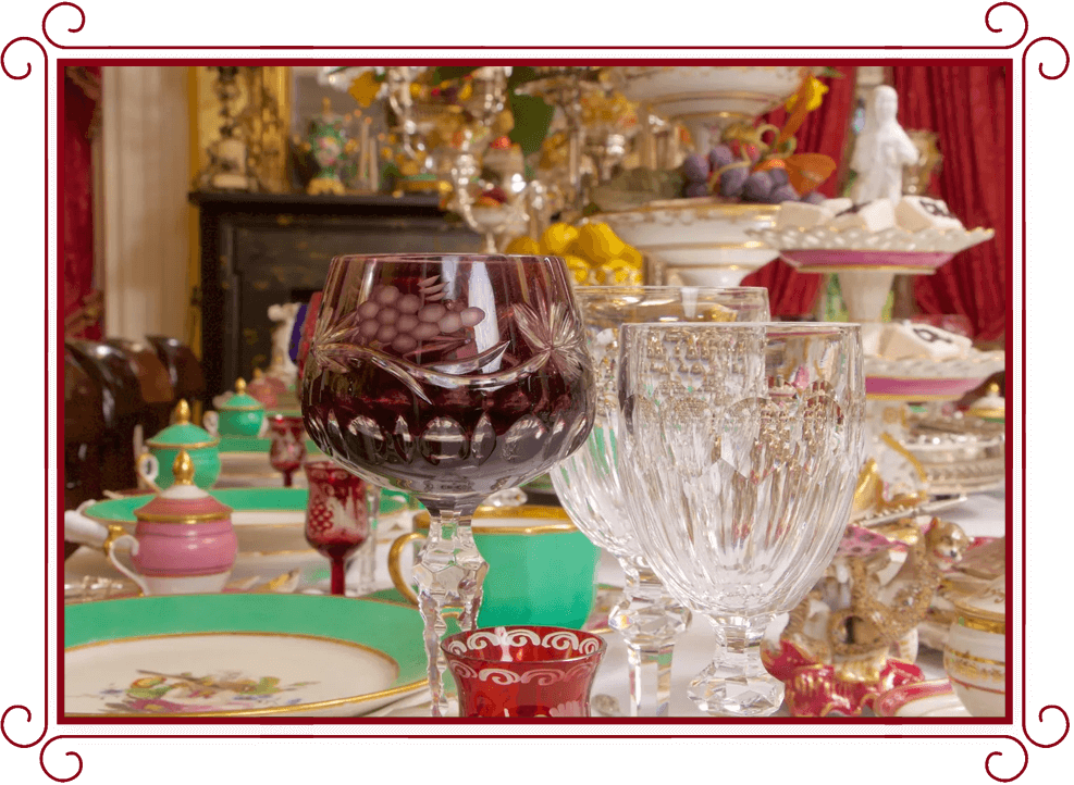 A table set with wine glasses and plates.